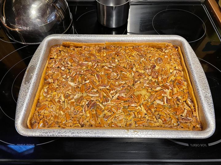 Pecan pie cobbler in a 9x13 dish with golden crust and caramelized pecan topping