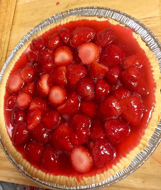 A homemade strawberry pie with a golden crust and glossy strawberry filling baked in a pie pan