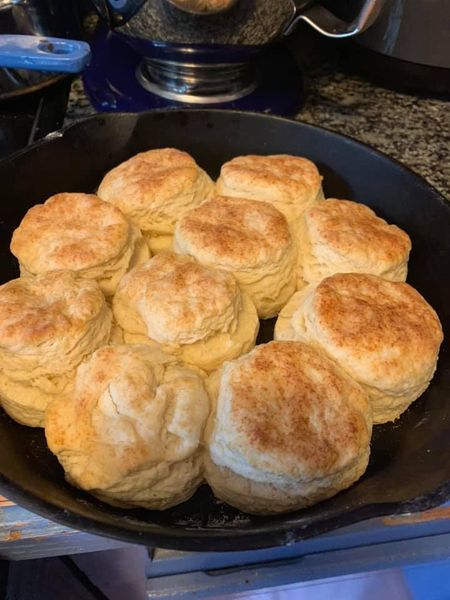 Golden-brown biscuits fresh from the oven in a cast iron skillet.