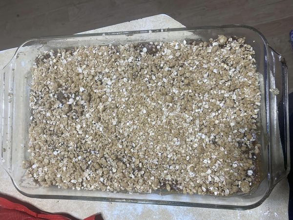 Unbaked oat crumble mixture in a glass dish, ready for the oven