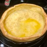 Dutch baby pancake in cast‑iron skillet – puffy and golden"