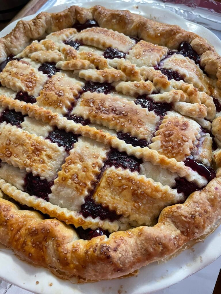 Golden brown four berry pie ready for slicing