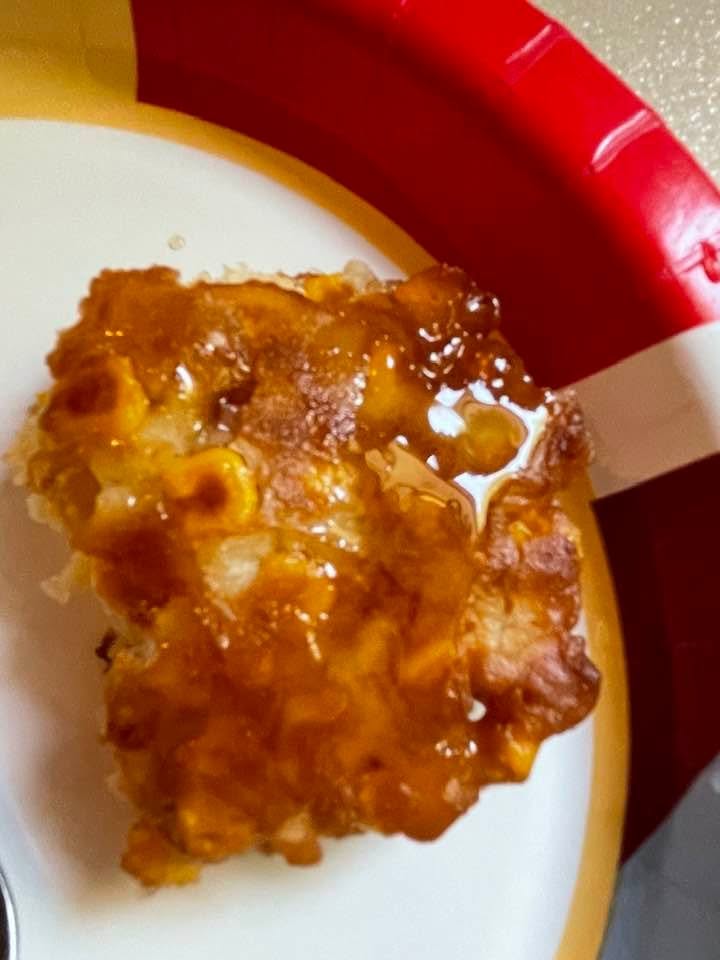 A blue bowl filled with fresh corn fritter batter made from flour, eggs, milk, and sweet corn kernels.
