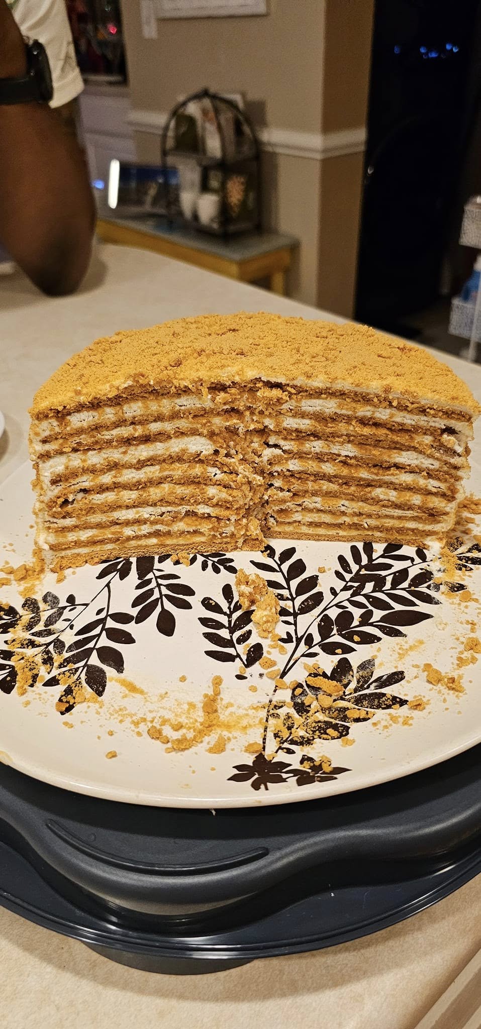 Slice of Medovik honey cake showing thin honey cake layers with creamy filling.