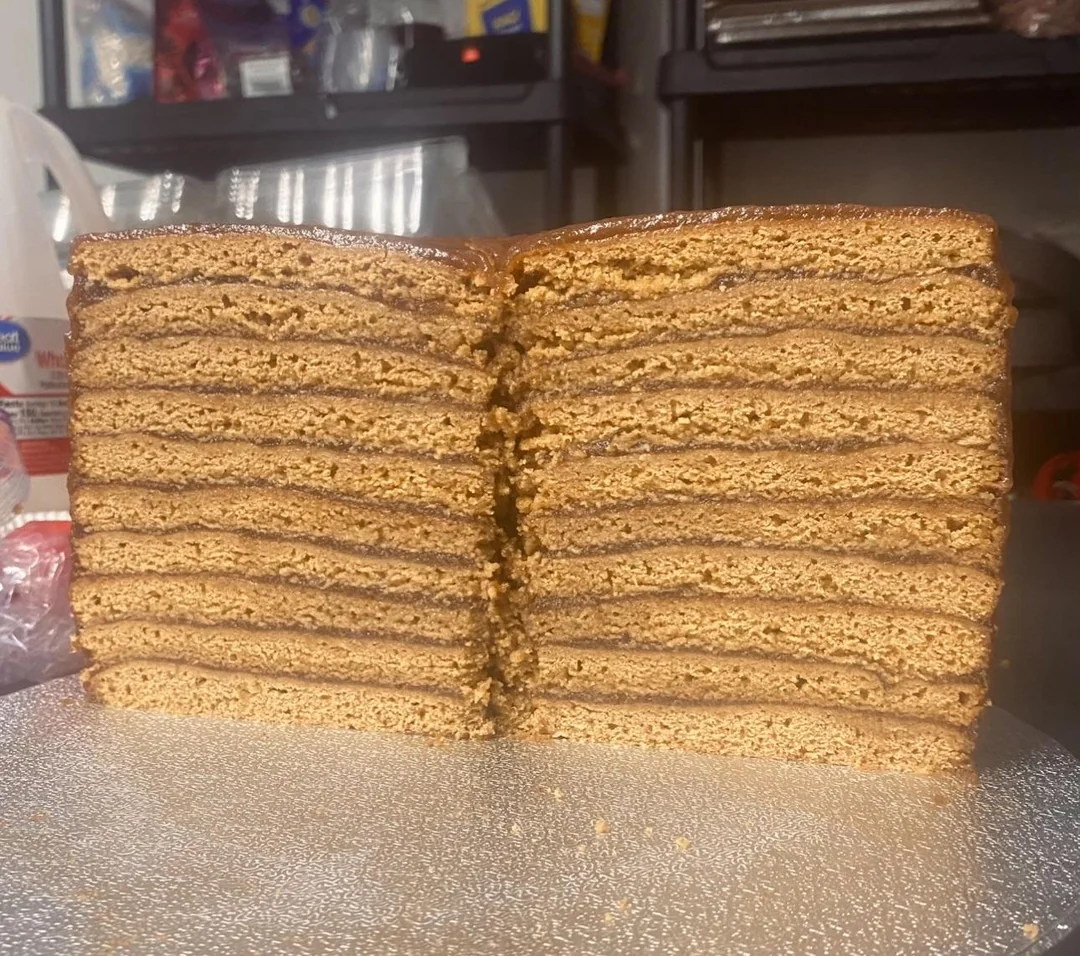 A beautiful cross-section of a 10-layer Appalachian Apple Stack Cake, featuring thin, soft gingerbread-like cake layers alternating with rich, dark spiced apple filling.
