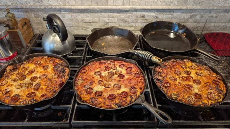 Three 10-inch cast iron skillets on a stovetop, each holding a freshly baked, thick-crust pan pizza loaded with caramelized cheese and pepperoni.