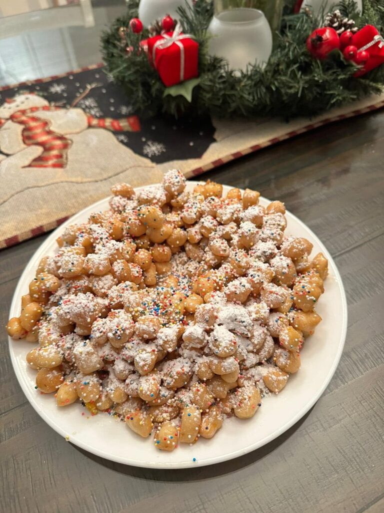Traditional Italian Christmas struffoli made with golden fried dough balls coated in honey and decorated with colorful sprinkles.