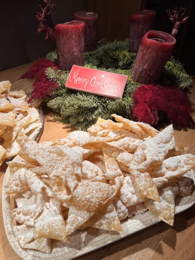 showing the dough being shaped, fried, and finished with powdered sugar.
