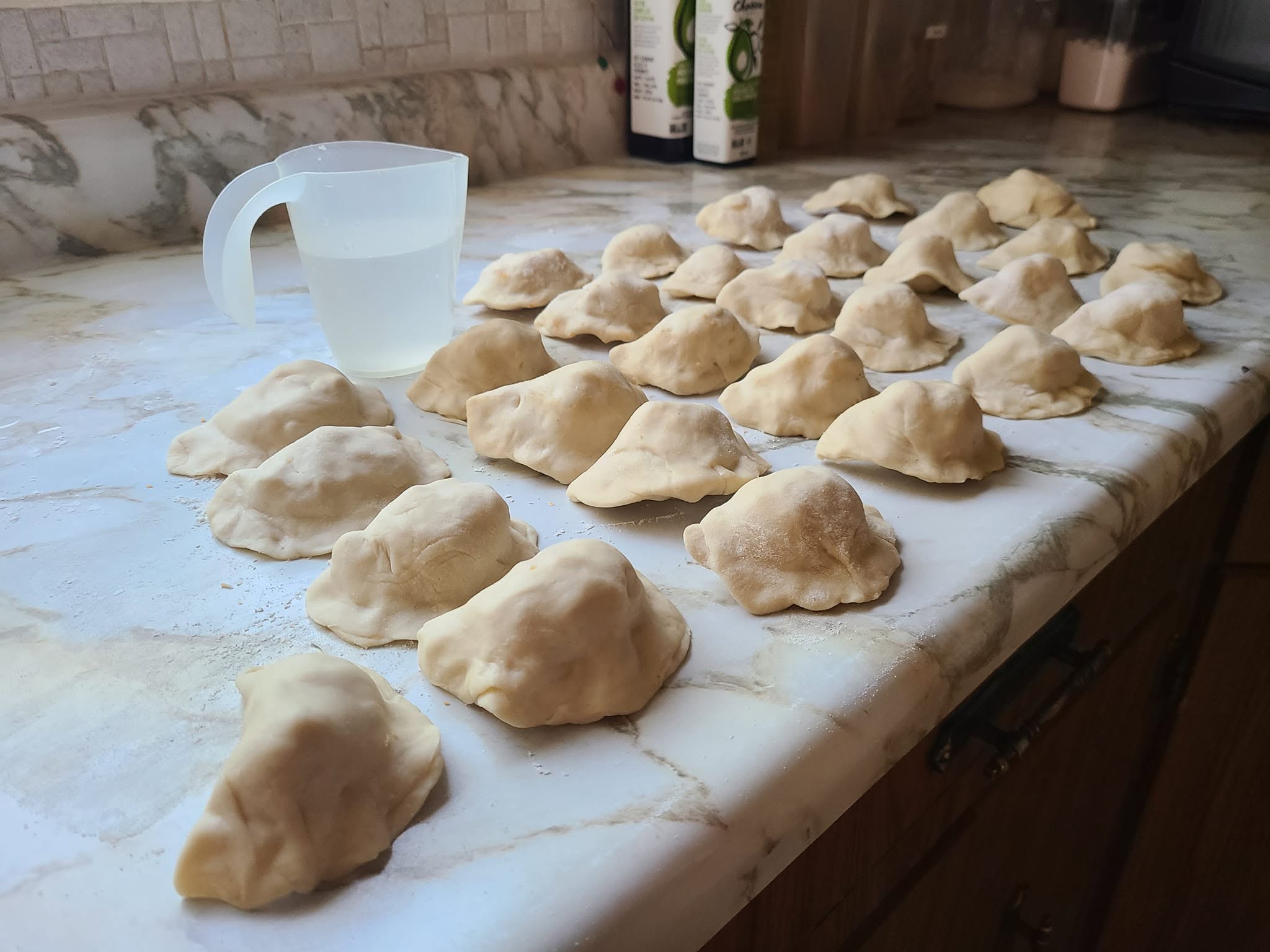 Traditional homemade Polish pierogi filled with potatoes and cheese, shaped and ready for boiling