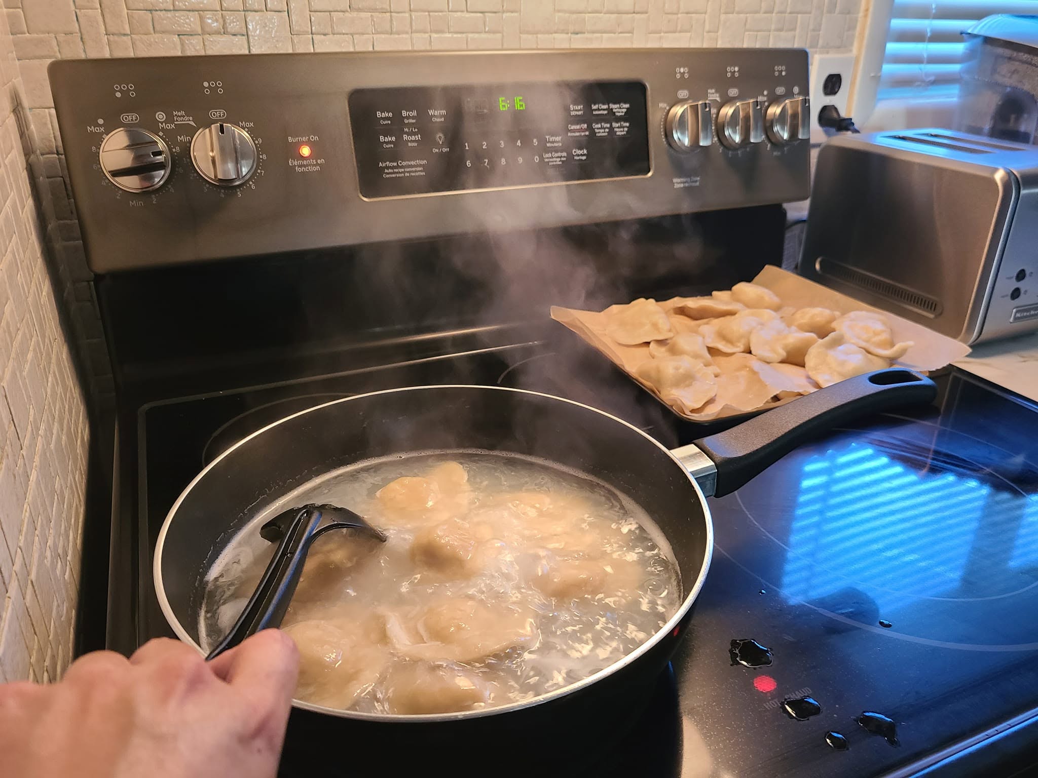 Homemade Polish potato and cheese pierogi cooking in boiling salted water