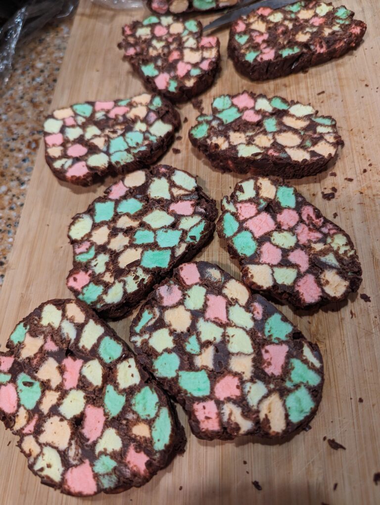 Homemade old-fashioned stained glass window candy with pastel marshmallows surrounded by chocolate and coated in shredded coconut.