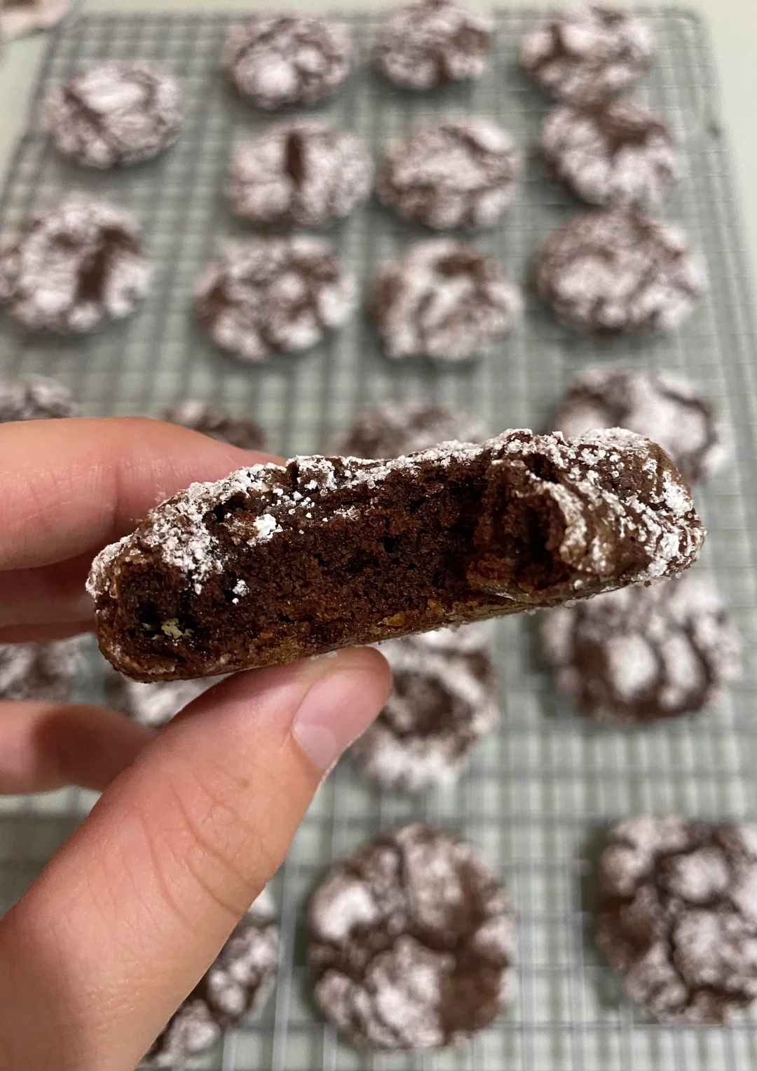 Stack of homemade brownie mix crinkle cookies with dark chocolate cracks and thick powdered sugar coating