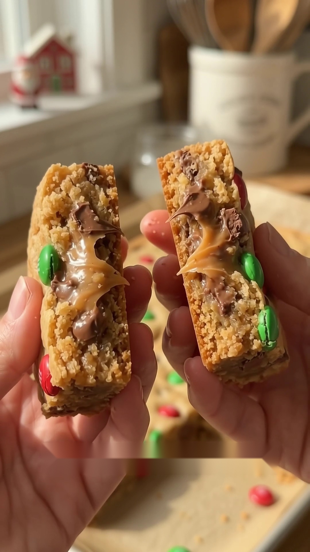 Christmas cookie bar broken in half showing a soft chewy center with melted chocolate and colorful holiday candies.