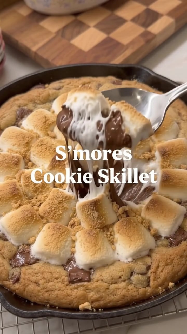 Gooey S’mores Cookie Skillet with melted chocolate and stretchy toasted marshmallow on a spoon